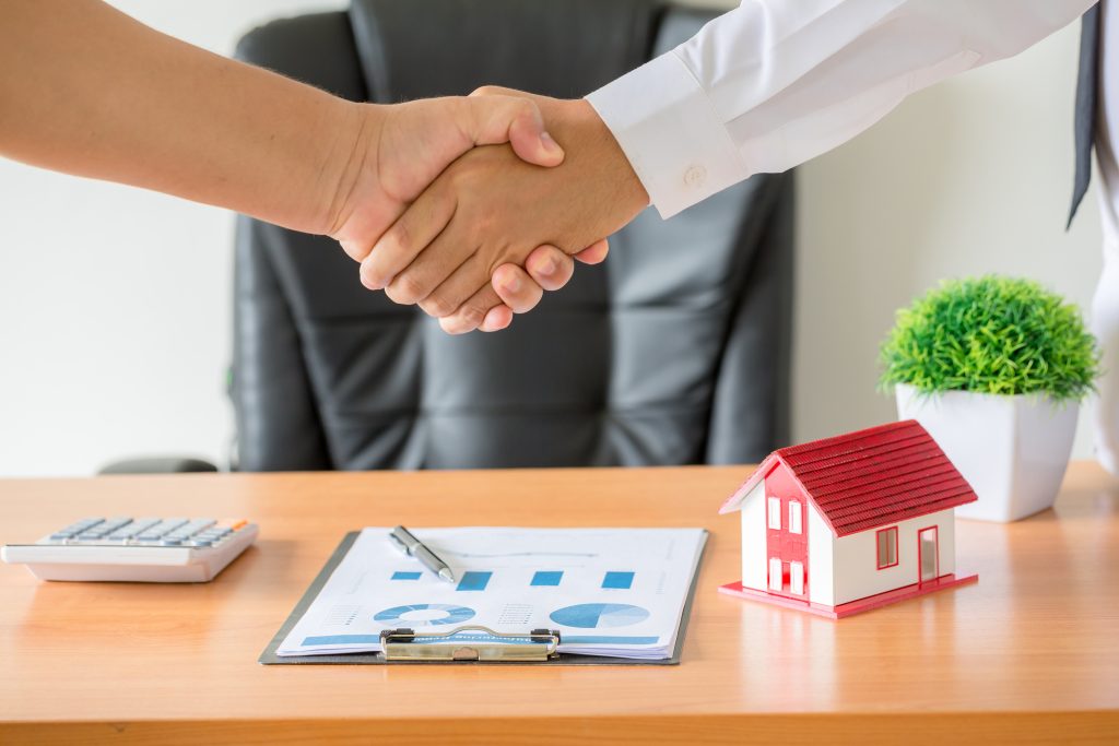 hands of agent and client shaking hands after signed contract buy new apartment